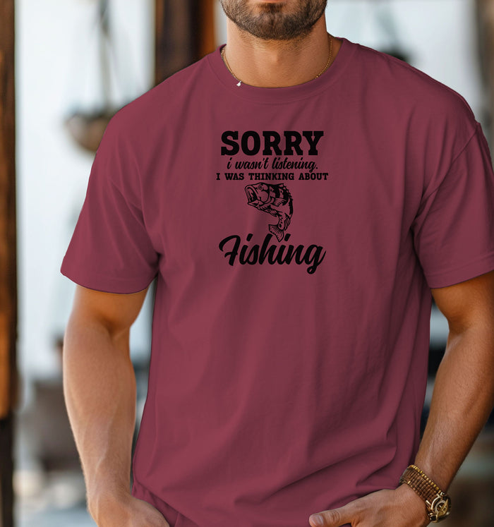 SORRY I wasn’t listening. I was thinking about Fishing' T-shirt featuring bold and script fonts with a detailed fish illustration. Printed on a chili unisex tee, this humorous design is perfect for fishing enthusiasts who’d rather be on the water than anywhere else. Ideal for casual wear, fishing trips, or as a fun gift for anglers and dads who love the sport.
