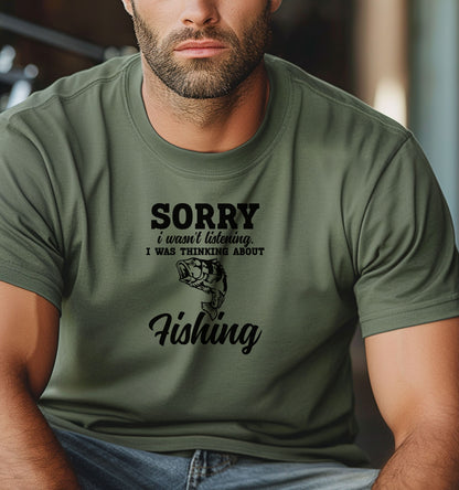 SORRY I wasn’t listening. I was thinking about Fishing' T-shirt featuring bold and script fonts with a detailed fish illustration. Printed on a moss unisex tee, this humorous design is perfect for fishing enthusiasts who’d rather be on the water than anywhere else. Ideal for casual wear, fishing trips, or as a fun gift for anglers and dads who love the sport.
