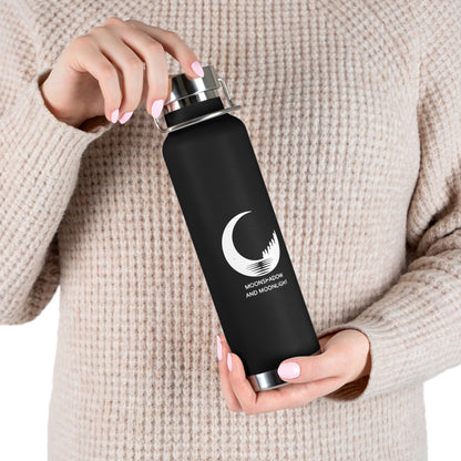 Person holding a black water bottle with a logo and text, wearing a beige sweater.