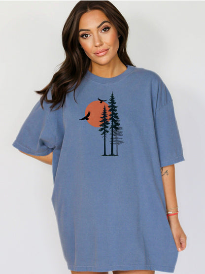 Sunset Pines & Soaring Eagles T-shirt featuring a minimalist nature design with tall pine trees silhouetted against a warm orange sun. Two eagles glide through the sky, adding a touch of wilderness and freedom. Printed on a blue jean unisex tee, this nature-inspired graphic is perfect for outdoor lovers, hikers, and those who appreciate serene, scenic beauty.