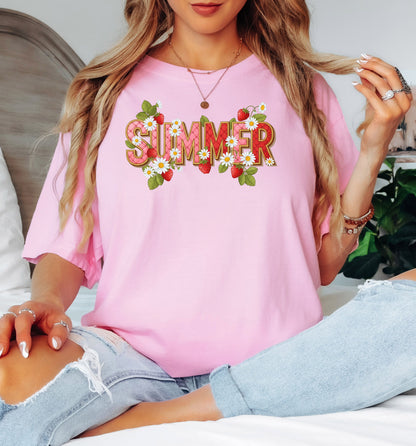 Blossom pink T-shirt featuring a vibrant “SUMMER” graphic decorated with red strawberries, green leaves, and white daisies. The fresh, playful design captures a bright and cheerful summer vibe, perfect for casual warm-weather outfits. 