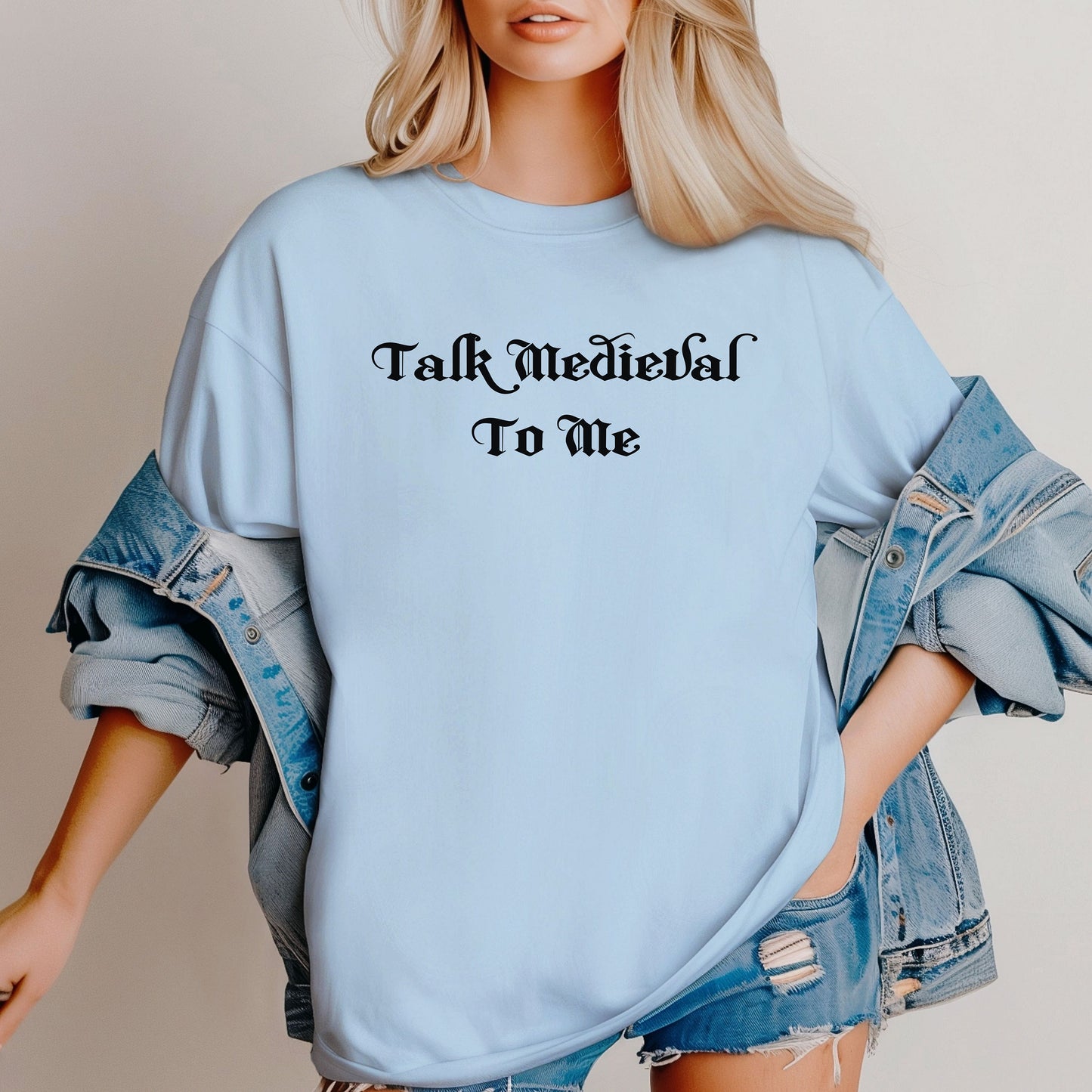 Chambray light blue T-shirt featuring the phrase “Talk Medieval To Me” in a bold, Gothic-style blackletter font. Perfect for Renaissance Faire lovers, history buffs, and medieval festival goers who enjoy witty and playful designs that show off their love for knights, castles, and all things medieval.