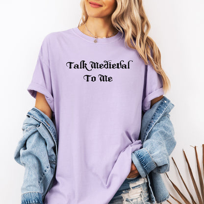 Orchid T-shirt featuring the phrase “Talk Medieval To Me” in a bold, Gothic-style blackletter font. Perfect for Renaissance Faire lovers, history buffs, and medieval festival goers who enjoy witty and playful designs that show off their love for knights, castles, and all things medieval.