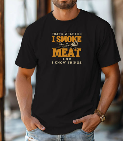 That's What I Do, I Smoke Meat & I Know Things T-shirt featuring bold text in yellow and white with crossed grilling tools at the center. Printed on a black unisex tee, this fun BBQ-themed design is perfect for grill masters and smoking enthusiasts. Ideal for Father’s Day, cookouts, and casual wear for those proud of their grilling skills and witty sense of humor.