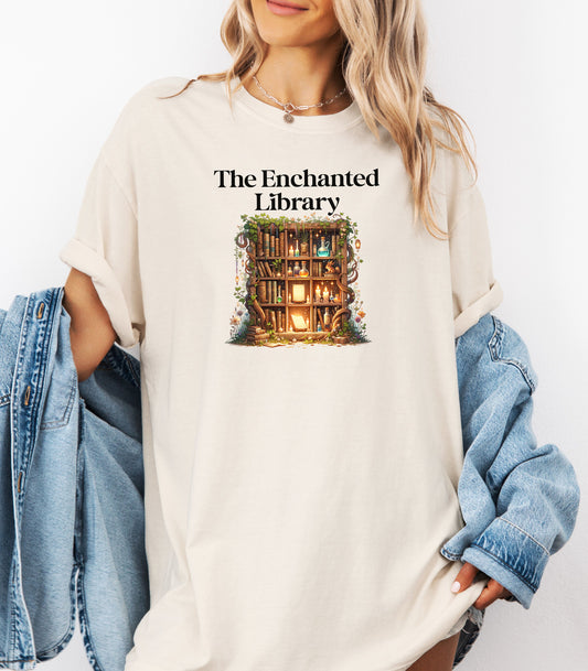 Woman wearing an Ivory t-shirt featuring a magical design titled "The Enchanted Library." The graphic shows a glowing bookshelf framed by vines, candles, books, and potions, evoking a whimsical, fantasy-inspired library setting. Perfect for book lovers and fans of enchanted tales.