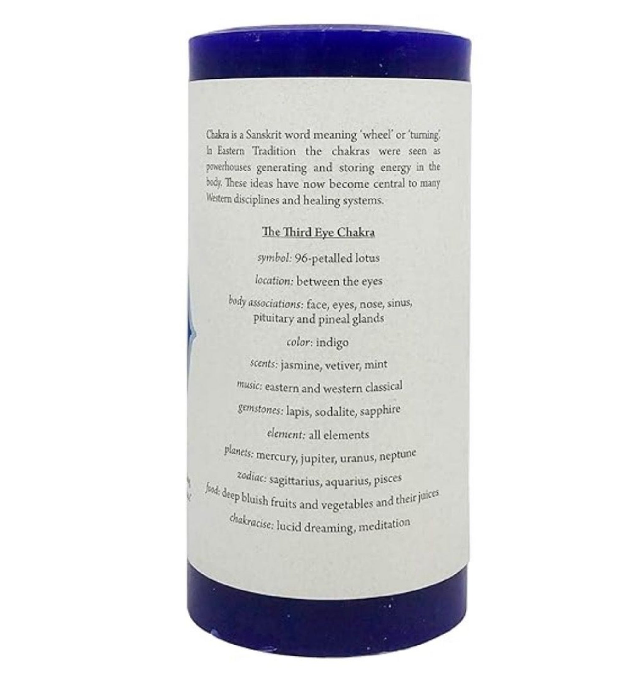 Back of the Third Eye Chakra pillar candle detailing chakra meaning, symbol (96-petalled lotus), location (between the eyes), and associations with face, eyes, sinuses, and glands. Describes indigo color, jasmine, vetiver, and mint scents, classical music, related gemstones (lapis, sodalite, sapphire), and planets. Includes zodiac signs, food suggestions, and chakracise practices like lucid dreaming and meditation.