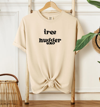 Tree Hugger T-shirt featuring bold retro-style black lettering on an ivory unisex Comfort Colors tee. Perfect for nature lovers, environmentalists, and eco-conscious outdoor enthusiasts who appreciate a vintage vibe while showing their love for trees, conservation, and the planet.