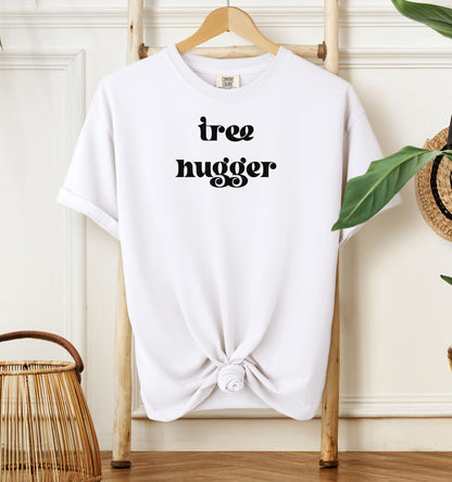Tree Hugger T-shirt featuring bold retro-style black lettering on a white unisex Comfort Colors tee. Perfect for nature lovers, environmentalists, and eco-conscious outdoor enthusiasts who appreciate a vintage vibe while showing their love for trees, conservation, and the planet.