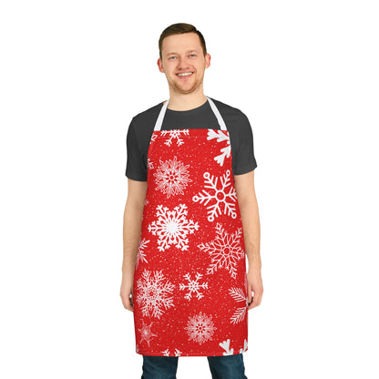 Apron with a festive red background covered in white snowflakes, creating a cheerful winter and Christmas-inspired design for holiday cooking.