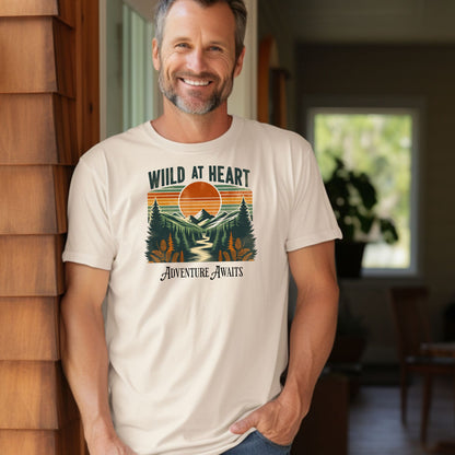 Vintage-style “Wild at Heart” graphic featuring a bold retro sunset over a pine forest and mountain scene, with a winding river flowing through the center. Warm earth tones—orange, green, and cream—create a nostalgic outdoor vibe. Ideal for adventure lovers and nature enthusiasts on a Comfort Colors Ivory t-shirt.