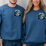 Indigo Blue Gildan sweatshirt featuring a “Wilderness Strong” design on the pocket area with a detailed illustration of a majestic wolf in a misty forest. The powerful graphic symbolizes resilience, strength, and connection to nature—ideal for outdoor lovers, wildlife fans, and those who embody the spirit of the wild.