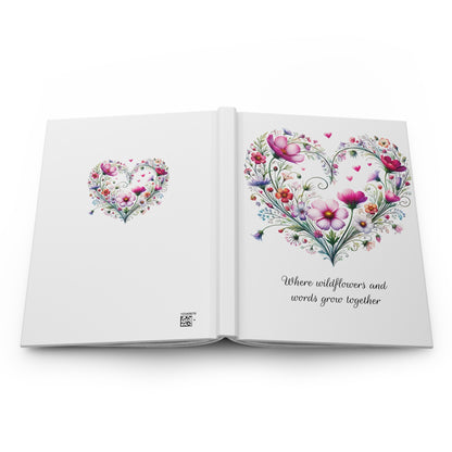 Open book with wildflower floral heart design on a white background