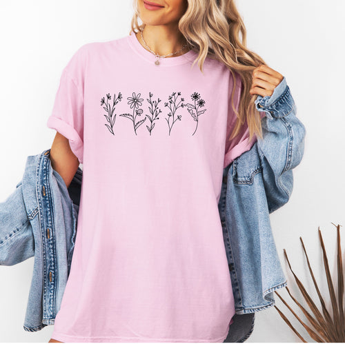 Blossom Comfort Colors® t-shirt featuring a minimalist white line art wildflower design across the chest. Simple hand-drawn botanical outlines create a delicate and nature-inspired look, perfect for plant lovers, gardeners, and boho style. Soft, relaxed fit ideal for casual everyday wear.