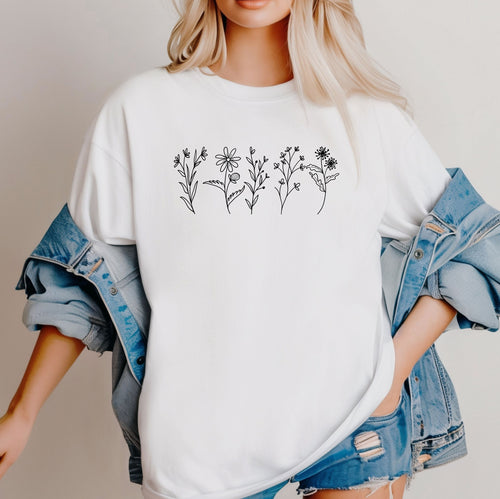 White Comfort Colors® t-shirt featuring a minimalist white line art wildflower design across the chest. Simple hand-drawn botanical outlines create a delicate and nature-inspired look, perfect for plant lovers, gardeners, and boho style. Soft, relaxed fit ideal for casual everyday wear.