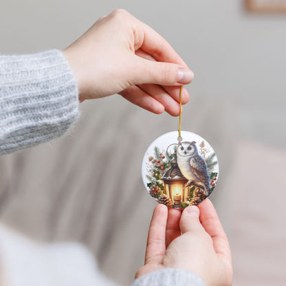Hand holding a ceramic Christmas ornament with an owl design against a neutral background