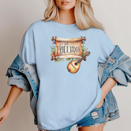 Chambray T-shirt featuring a whimsical Renaissance Faire design with the words “Ye Olde Faire” written on a scroll accented by flowers and greenery, alongside a medieval-style lute. Perfect for festival goers, music lovers, and fans of historical fairs, knights, and old-world charm.