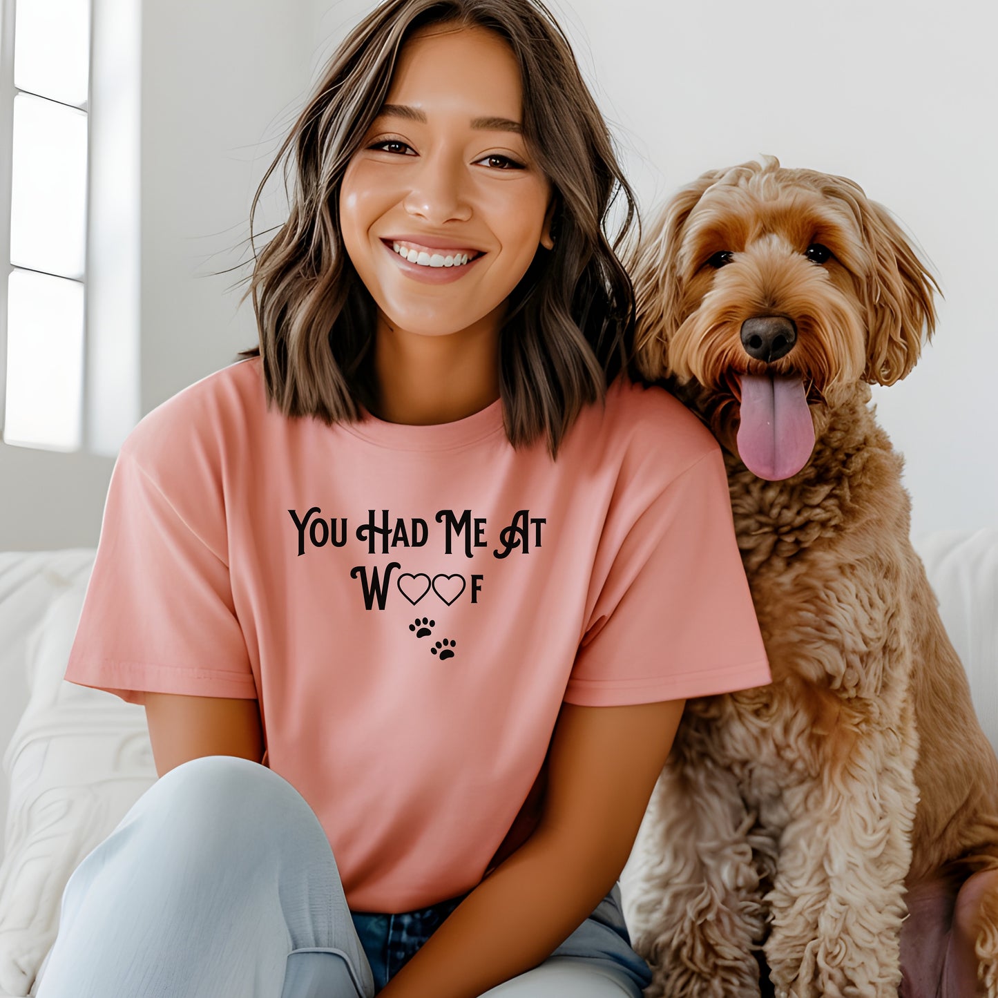 Person wearing a sunset T-shirts featuring the phrase “You Had Me At Woof” in playful black text. The design includes heart shapes inside the letters and two small paw prints beneath, creating a cute and stylish look perfect for dog lovers and pet owners.