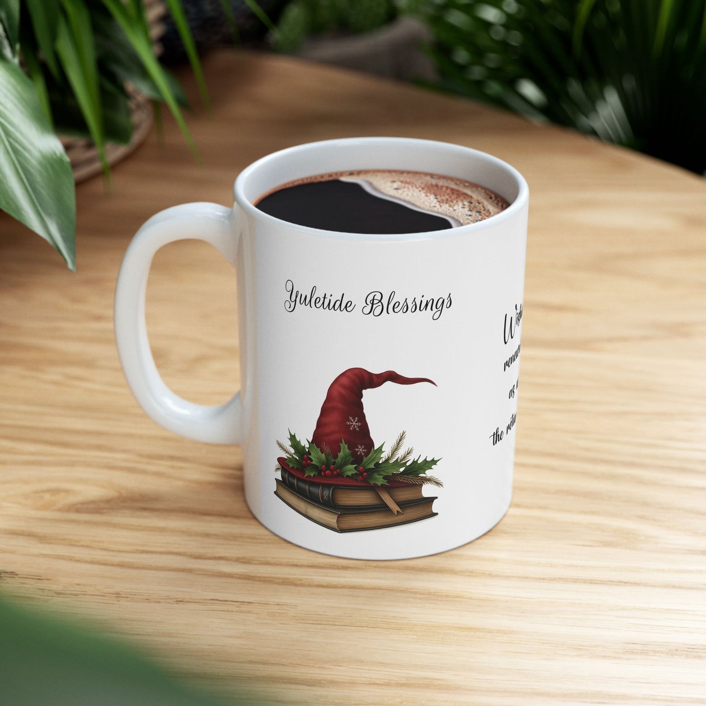 White ceramic mug with a festive Yuletide Blessings design on a wooden table