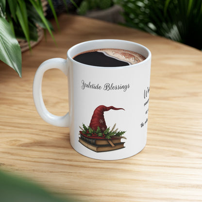 White ceramic mug with a festive Yuletide Blessings design on a wooden table