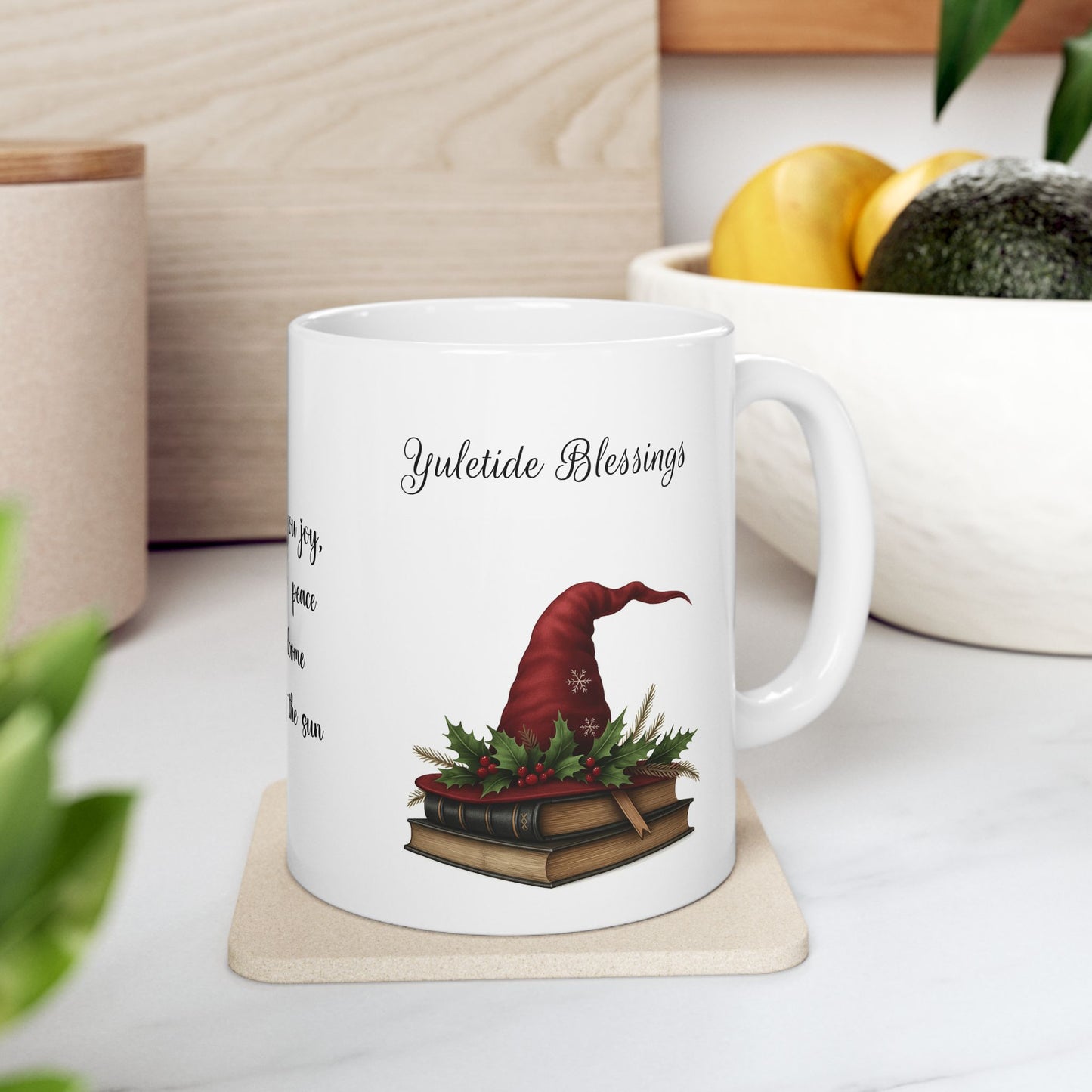 White ceramic mug with a festive design and 'Yuletide Blessings' text on a coaster.