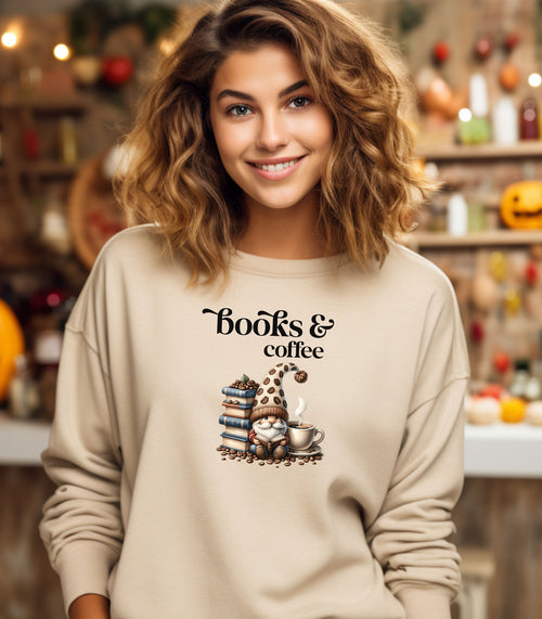 Sand Gildan sweatshirt featuring an adorable “Books & Coffee” design with a cozy gnome wearing a polka-dot hat, sitting beside a stack of books, a steaming coffee cup, and scattered coffee beans. A charming and whimsical design perfect for book lovers, coffee enthusiasts, and fall vibes.