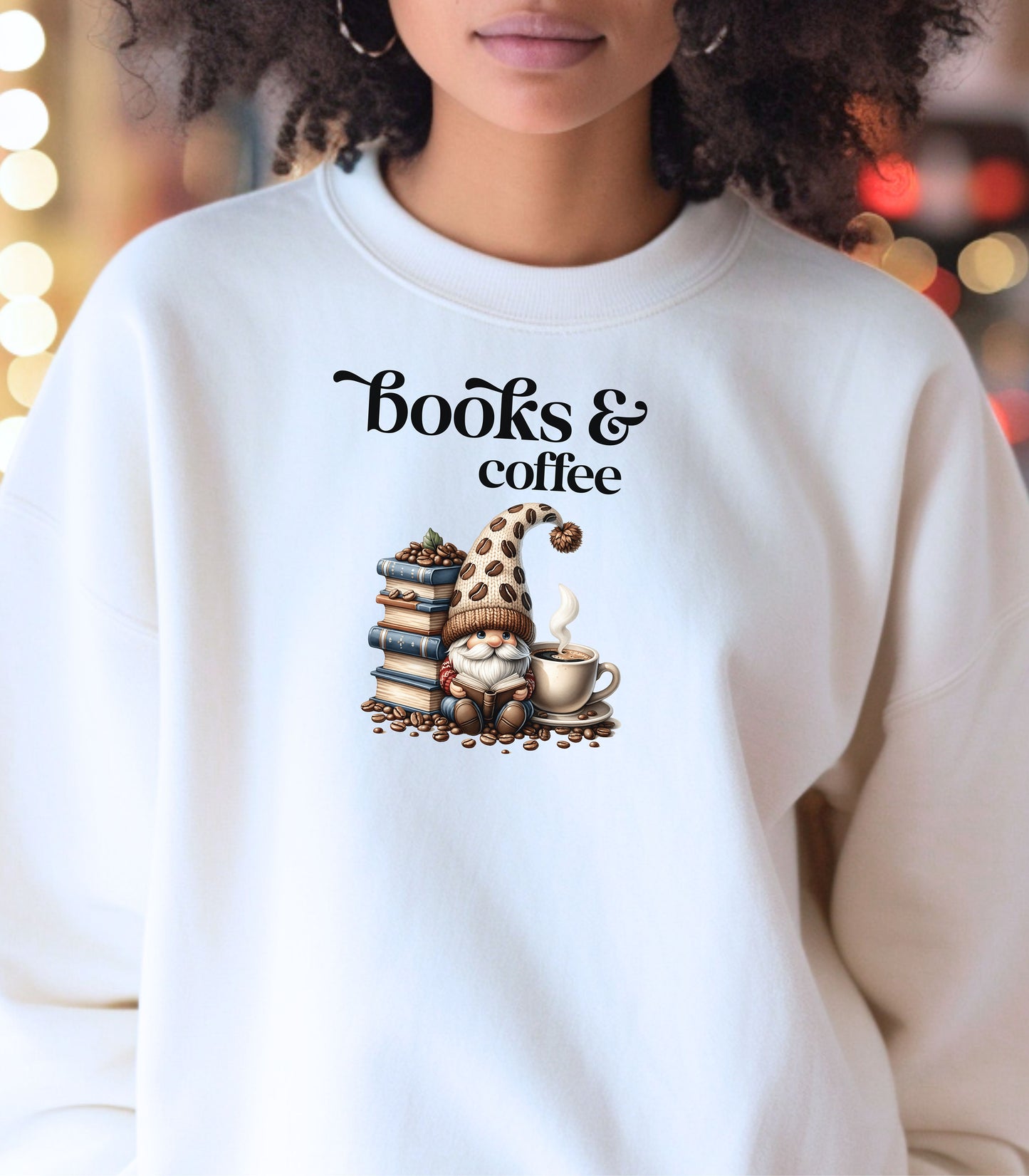 White Gildan sweatshirt featuring an adorable “Books & Coffee” design with a cozy gnome wearing a polka-dot hat, sitting beside a stack of books, a steaming coffee cup, and scattered coffee beans. A charming and whimsical design perfect for book lovers, coffee enthusiasts, and fall vibes.