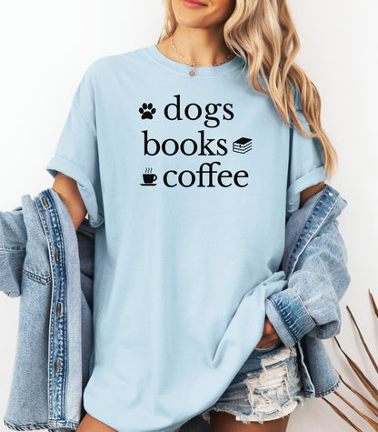 Black graphic design on a Chambray light blue t-shirt featuring the phrase “Dogs, Books, Coffee” in bold, playful lettering. Decorative icons of a dog paw, stacked books, and a steaming coffee cup enhance the cozy, laid-back vibe—perfect for dog lovers, bookworms, and caffeine enthusiasts alike.