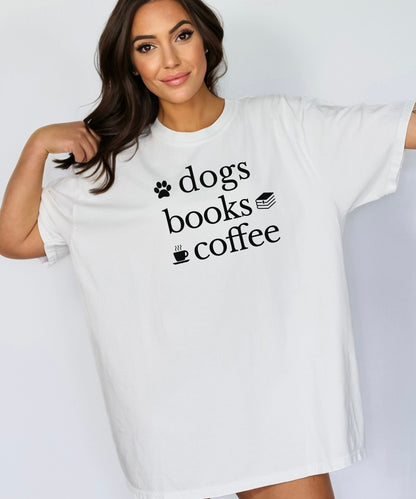 Black graphic design on a white t-shirt featuring the phrase “Dogs, Books, Coffee” in bold, playful lettering. Decorative icons of a dog paw, stacked books, and a steaming coffee cup enhance the cozy, laid-back vibe—perfect for dog lovers, bookworms, and caffeine enthusiasts alike.